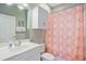 Well-lit bathroom features a vanity with storage and a patterned shower curtain at 4803 Bovardia Pl. # 102, Myrtle Beach, SC 29577