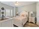 Bright bedroom with white furniture, ceiling fan, and wood-look flooring at 4803 Bovardia Pl. # 102, Myrtle Beach, SC 29577