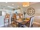 Charming dining area featuring a modern light fixture, wooden table with seating, and access to the kitchen and living space at 4803 Bovardia Pl. # 102, Myrtle Beach, SC 29577