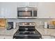Close up of the kitchen range and microwave, with white cabinets and light granite countertops at 4803 Bovardia Pl. # 102, Myrtle Beach, SC 29577