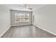 Sun-filled bedroom boasts hardwood floors, neutral paint, large window with outdoor views, and access to a patio at 4940 Windsor Green Way # 203, Myrtle Beach, SC 29579