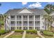 Charming condo building with white siding, multiple balconies, and lush landscaping at 4940 Windsor Green Way # 203, Myrtle Beach, SC 29579