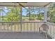 Screened patio overlooking the golf course surrounded by mature trees, showing a lone chair and carpeted flooring at 4940 Windsor Green Way # 203, Myrtle Beach, SC 29579