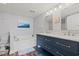Bright bathroom featuring double sinks with blue cabinetry and tub with seaside themed decor at 501 S Ocean Blvd. # 307, North Myrtle Beach, SC 29582