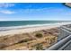 Balcony view overlooking the beach, dunes, chairs and lounges on sunny day at 5200 N Ocean Blvd. # 937, Myrtle Beach, SC 29577