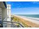 Beautiful beach view from the balcony of this condo, with a wide sandy beach, palm trees and a blue sky at 5200 N Ocean Blvd. # 937, Myrtle Beach, SC 29577