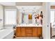 Dual sink bathroom vanity with wood cabinets, tub, and large mirror at 540 Alderly Ct., Little River, SC 29566