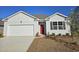 Charming single-story home featuring a red front door, garage, and well-maintained landscaping at 559 Firouz Dr, Longs, SC 29568