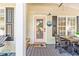 Inviting front porch with a cute pink door, funny doormat, outdoor dining table, and relaxing adirondack chairs at 6001 - T33 South Kings Hwy., Myrtle Beach, SC 29575