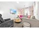 Comfortable living room features a sectional sofa, flamingo wallpaper, modern decor, and a wall-mounted TV at 6001 - T33 South Kings Hwy., Myrtle Beach, SC 29575