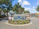 The Ocean Keyes entrance sign is on a brick roundabout, with palm trees and a lake in the background at 601 N Hillside Dr. # 2235, North Myrtle Beach, SC 29582
