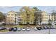 A yellow condominium building with white balconies overlooks the parking lot on a sunny day at 601 N Hillside Dr. # 2235, North Myrtle Beach, SC 29582