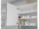 Open kitchen cabinets displaying glassware, bowls, and plates with beach-themed wall art at 601 N Hillside Dr. # 2235, North Myrtle Beach, SC 29582