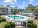 Community pool surrounded by lush landscaping, lounge chairs, and barbeque area at 601 N Hillside Dr. # 2235, North Myrtle Beach, SC 29582