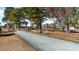 Well-maintained bocce ball court nestled among mature trees, offering a recreational space for residents at 6031 Forest Dell Ct, Myrtle Beach, SC 29579