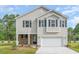 Charming two-story home with a stone-accented porch and a two-car garage, set against a backdrop of trees at 6031 Forest Dell Ct, Myrtle Beach, SC 29579