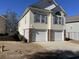 Two-story home featuring a two-car garage, yellow siding, and complementing shutters, under a clear sky at 670 2Nd Ave. N, North Myrtle Beach, SC 29582