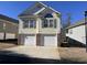 Two-story home featuring a two-car garage, yellow siding, and complementary shutters, set in a residential area at 670 2Nd Ave. N, North Myrtle Beach, SC 29582