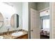 Well-lit bathroom featuring granite countertops, dual sinks, and view to bedroom at 705 Beach Walk Pl. # 705, Myrtle Beach, SC 29577
