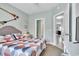 Comfortable bedroom featuring inviting queen size bed, ensuite bathroom, and a full view to the living room at 705 Beach Walk Pl. # 705, Myrtle Beach, SC 29577