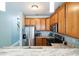 Well-equipped kitchen with stainless steel refrigerator, wooden cabinetry, and granite countertops at 705 Beach Walk Pl. # 705, Myrtle Beach, SC 29577