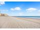 Expansive sandy beach with clear blue ocean and cloud-dotted sky at 707 S Ocean Blvd. # 304, North Myrtle Beach, SC 29582