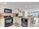 Open kitchen featuring granite countertops and black appliances, extending to dining area at 707 S Ocean Blvd. # 304, North Myrtle Beach, SC 29582