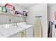 Functional laundry area with washer, dryer, shelving, and ironing board at 707 S Ocean Blvd. # 304, North Myrtle Beach, SC 29582
