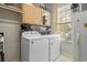 Functional laundry room with washer, dryer, storage cabinets, and a bright window at 728 Elizabeth Dr., Murrells Inlet, SC 29576