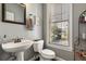 Powder room featuring a pedestal sink, toilet, framed mirror, and natural light at 728 Elizabeth Dr., Murrells Inlet, SC 29576
