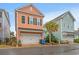 A two-story orange house with a white garage door and black shutters under a blue sky at 7809 Monarch Dr., Myrtle Beach, SC 29572