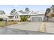 Single-story home with a metal roof, solar panels, red shutters, a front porch, and a two-car garage at 810 Finger Lake Dr., Myrtle Beach, SC 29588