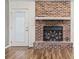 Cozy living room features a brick fireplace, wood floors, and access to the backyard at 810 Finger Lake Dr., Myrtle Beach, SC 29588