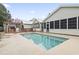 Backyard swimming pool with a concrete deck, covered patio, and adjacent house with a screened-in porch at 810 Finger Lake Dr., Myrtle Beach, SC 29588