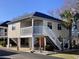 Charming raised beach home with white railings, staircases, and pleasing color palette at 820 9Th Ave. S, North Myrtle Beach, SC 29582