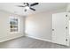 This bedroom features a window, lighted ceiling fan, neutral paint and wood-look flooring at 822 Highway 90, Conway, SC 29526