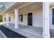 Inviting front porch with sturdy white columns, black accents, and professionally landscaped flower beds at 822 Highway 90, Conway, SC 29526