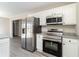 Kitchen featuring stainless steel appliances, white cabinets, and gray vinyl flooring at 822 Highway 90, Conway, SC 29526