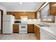 Well-lit kitchen featuring modern white appliances, wood cabinets and tile flooring at 830 44Th Ave. N # L2, Myrtle Beach, SC 29577