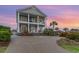 Two-story home with white columns, green siding, and lush landscaping provides tons of curb appeal at 898 Bluffview Dr., Myrtle Beach, SC 29579