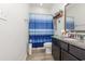 Bathroom with single sink vanity, shower and blue curtain at 909 Witherbee Way, Little River, SC 29566