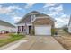 Charming two-story home featuring a mix of stone and siding, a two-car garage, and a well-manicured lawn at 909 Witherbee Way, Little River, SC 29566