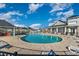 Community pool with chairs and tables and a nearby outdoor lounge area with ceiling fans at 909 Witherbee Way, Little River, SC 29566