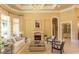 Bright living room featuring a fireplace, elegant furniture, decorative curtains, and an arched doorway at 9200 Bellasera Circle, Myrtle Beach, SC 29579