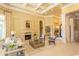 A sun-filled living room boasts a coffered ceiling, neutral walls, and a cozy fireplace beneath a striking piece of artwork at 9200 Bellasera Circle, Myrtle Beach, SC 29579