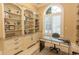 Stylish office space features custom built-in bookshelves, a large window with shutters, and a modern desk at 9200 Bellasera Circle, Myrtle Beach, SC 29579