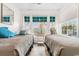 Bright bedroom with two twin beds, wood-look floors, and many windows at 9750 Leyland Dr. # 2, Myrtle Beach, SC 29572