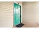 Close-up of teal front door with welcome mat, offering an inviting entrance to the residence at 9750 Leyland Dr. # 2, Myrtle Beach, SC 29572
