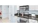 Kitchen featuring stainless steel oven and microwave, granite countertops, and white cabinets at 9750 Leyland Dr. # 2, Myrtle Beach, SC 29572