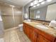 Bathroom featuring a double sink vanity with granite countertop and a glass-enclosed shower at 9820 Queensway Blvd. # 109, Myrtle Beach, SC 29572